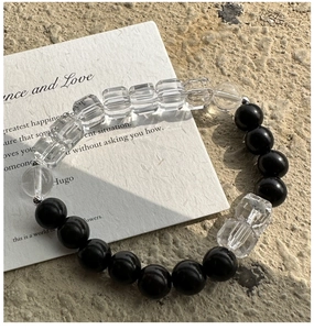 Macro view of minimalist beaded bracelet with black onyx spheres and clear crystal accents