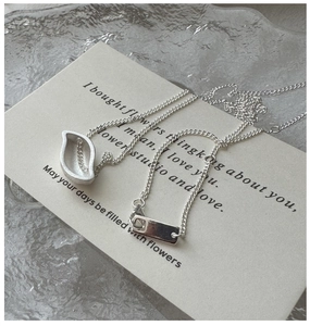 Detail of S925 silver leaf pendant with frosted texture and polished metal tag