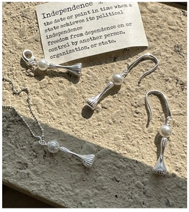 Macro detail of S925 silver pearl jewelry set with striped metal cones and bead chain
