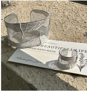Detailed close-up of S925 silver ring and cuff featuring unique mesh texture on rock surface