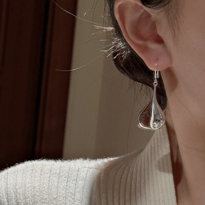 S925 sterling silver hollow teardrop earrings worn by a model in a minimalist style