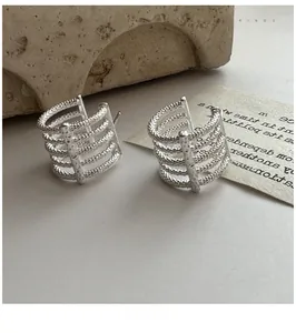 Macro shot of silver S925 multi-layered hoop earrings with hand-hammered texture
