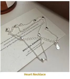 Detail of S925 sterling silver heart necklace with polished pendants on vintage card