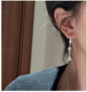 Detail of S925 sterling silver drop earring with pearl and lily of the valley charm on model