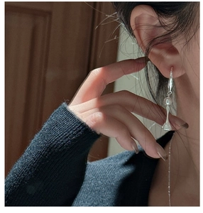 Detail of S925 silver drop earring featuring a white pearl and textured drum-shaped pendant