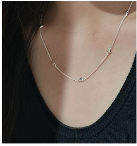 Close-up of minimalist S925 sterling silver necklace with heart pendants on neck