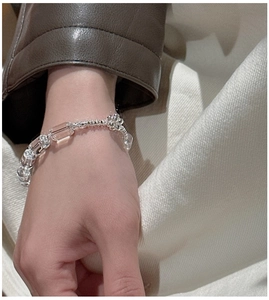 Macro shot of S925 silver beaded bracelet with clear rectangular crystals on female wrist