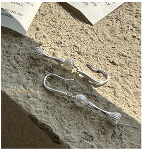 Close-up of vintage S925 silver earrings with round pearls and textured metal pendants
