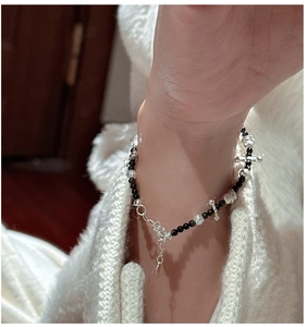 Close-up of S925 sterling silver beaded bracelet with black onyx beads and cross charm