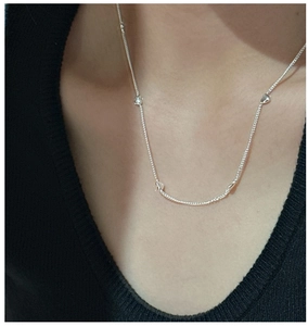 Macro view of S925 sterling silver minimalist heart necklace on female neck
