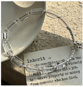 Detail showing square white crystal beads and S925 sterling silver charms on a bracelet