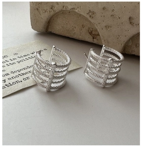 Macro shot of silver S925 earrings featuring a five-layer hammered metal texture design