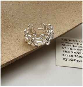Macro d'une bague fleur en argent avec zircons sur un support de présentation rustique