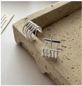 Detailed macro view of S925 sterling silver earrings with textured parallel bands