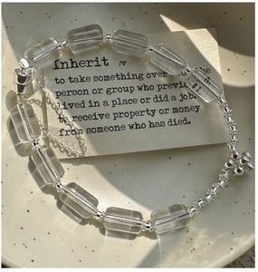 Detailed shot of a silver S925 beaded bracelet with clear square crystals in a ceramic dish