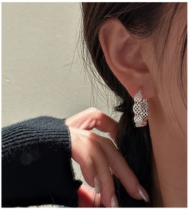 Gros plan sur des créoles minimalistes en argent sterling S925 avec motif en maille ajourée
