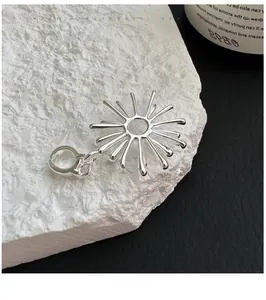 Macro shot of silver radial firework pendant on contrasting black leather and white stone