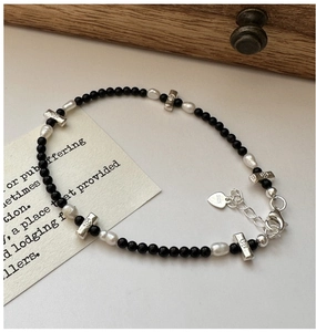 Close-up of S925 sterling silver heart tag with black onyx beads and freshwater pearls