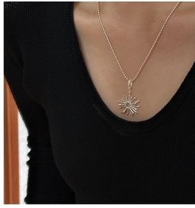 Detailed view of S925 sterling silver sunflower pendant worn on a beaded chain necklace