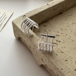Minimalist S925 sterling silver earrings with textured parallel rings on stone tray