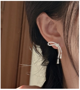 Vue macro de boucles d'oreilles nœud vintage en argent S925 avec texture torsadée et glands
