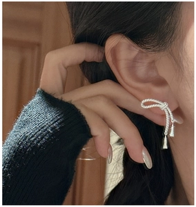 Gros plan de boucles d'oreilles nœud en argent S925 avec texture corde et glands
