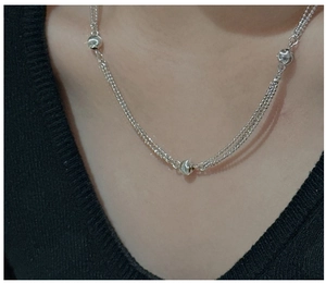 Close-up of triple-layered S925 sterling silver chain necklace with polished beads