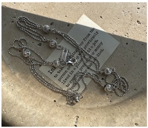 Detail of S925 sterling silver triple-layer necklace with textured beads and lobster clasp