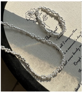 Detailed close-up of faceted S925 silver beaded jewelry with shimmering laser-cut texture