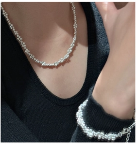 Detail von S925 Sterlingsilber Perlenkette und Armband Set auf schwarzem Stricktop