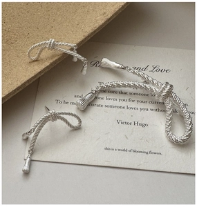 Vue détaillée des boucles d'oreilles nœud en argent S925 avec pompon rétro et texture torsadée