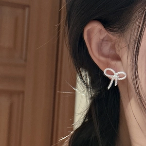 Elegant S925 sterling silver bow earrings with twisted texture worn by model