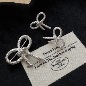Vintage S925 sterling silver bow earrings with twist texture on a black velvet background