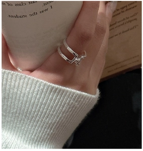 Detail view of a double-layered S925 sterling silver ring worn in a cozy lifestyle setting