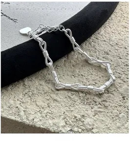 Dettaglio del bracciale a nodo in argento S925 con ciondolo a cuore e chiusura a moschettone