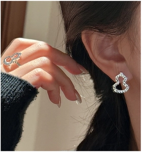 Close-up of S925 sterling silver gourd earrings and ring with textured finish