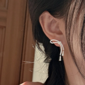 Élégantes boucles d'oreilles nœud en argent S925 avec pompons portées par un modèle