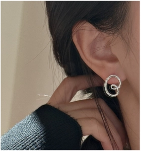 Close-up of S925 silver pretzel twist earrings on model showing minimalist design