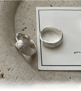 Detailed macro view of S925 sterling silver hoop earrings with brushed matte texture