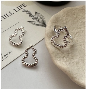 Macro detail of geometric hollow gourd earrings and ring in S925 sterling silver