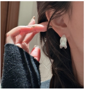 Close-up of minimalist S925 sterling silver multilayer wired earrings on a model's ear