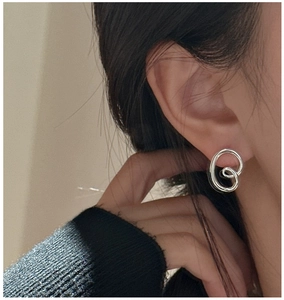 Close-up of S925 sterling silver pretzel knot stud earring worn by a model