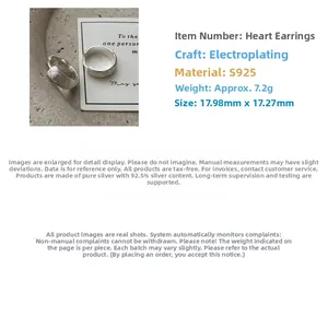 Macro shot of S925 sterling silver heart-embossed hoop earrings with brushed finish