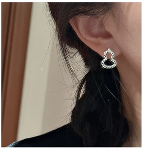Close-up of S925 sterling silver wulu stud earrings with textured finish on model