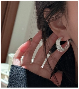 Close-up of S925 sterling silver multi-layered C-shaped earrings on a female model