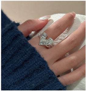 Close-up of S925 sterling silver heart ring with textured irregular finish on hand