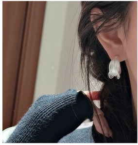 Close-up of minimalist S925 sterling silver multilayer coil earrings on a model
