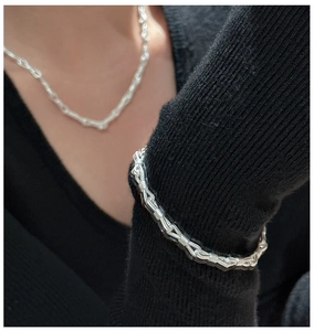 Dettaglio del bracciale in argento a nodi con lavorazione a filo su polsino nero