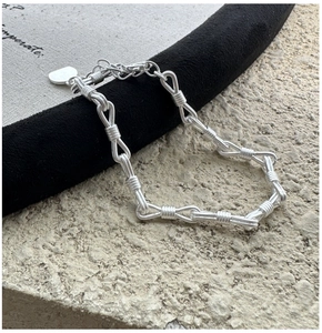 Dettaglio del bracciale a catena in argento con nodo e ciondolo a cuore su pietra