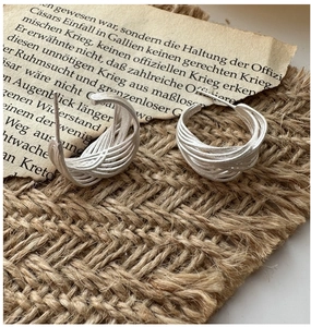 Macro detail of S925 sterling silver hoop earrings with woven wire texture and matte finish
